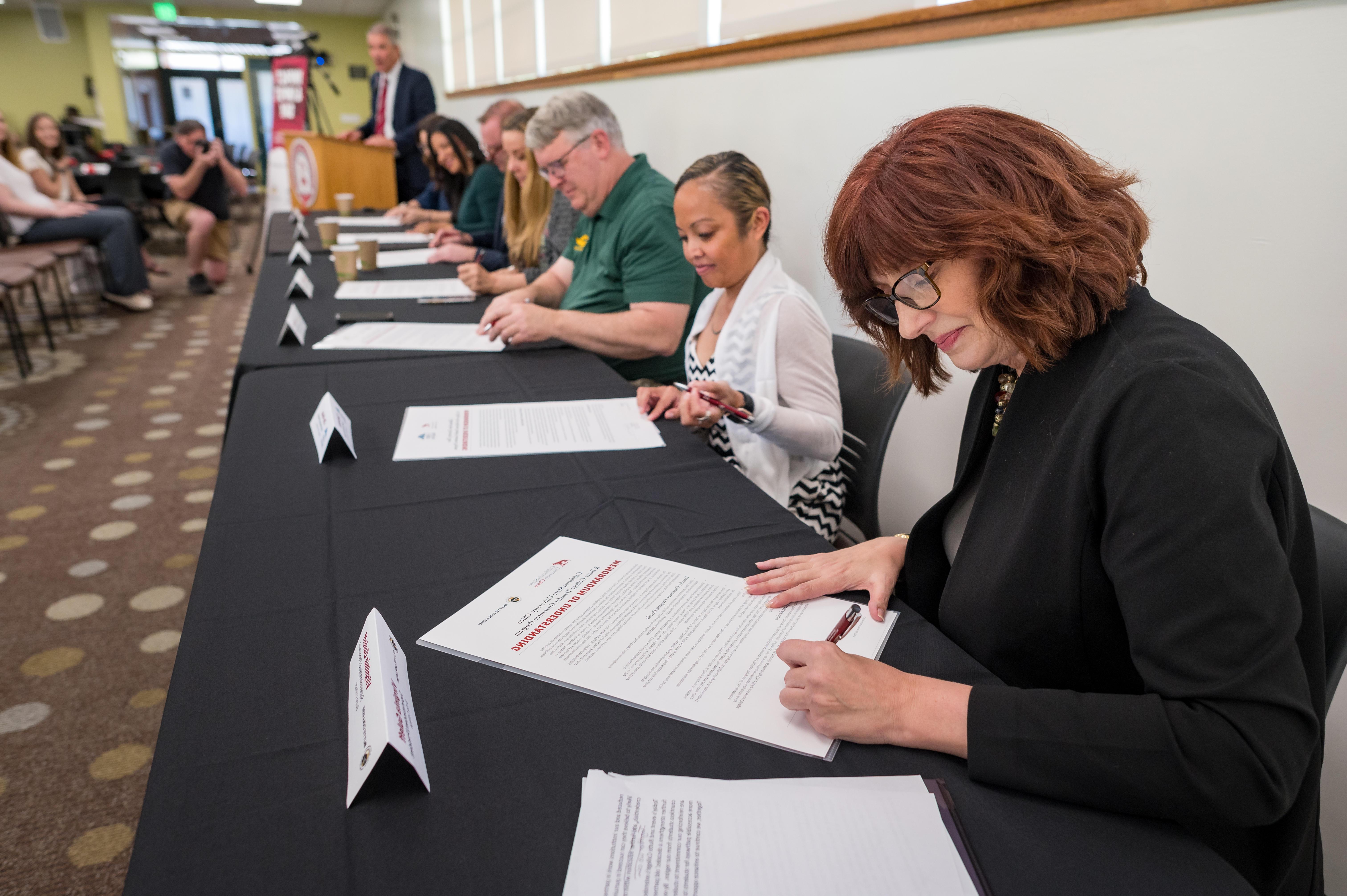 E世博ESBALL President Virginia Guleffis shown signing an MOU.